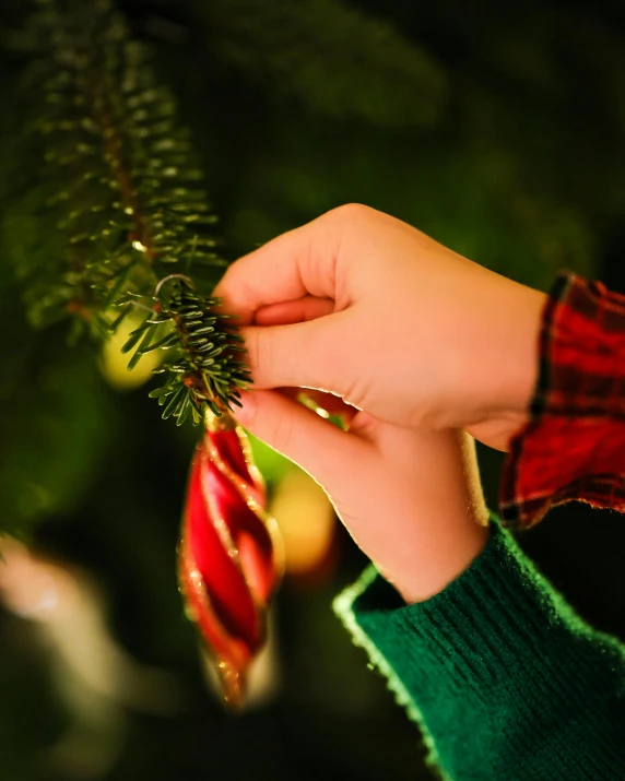 a person holding a small tree ornament in their hand