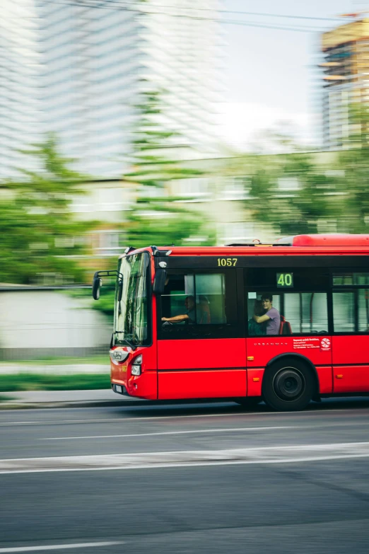 a red city bus drives down the street