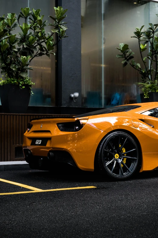 the large orange sports car is parked in front of the building