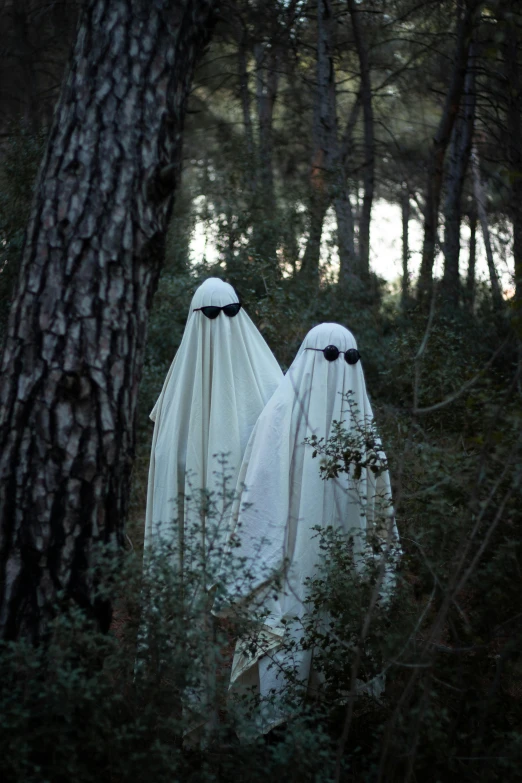 two ghost characters walking through a forest with trees