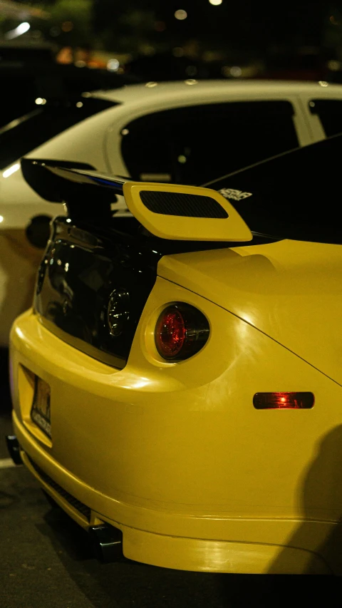 a yellow car parked next to another white car