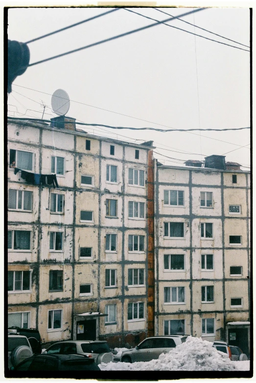 cars are parked along the street in front of a large building