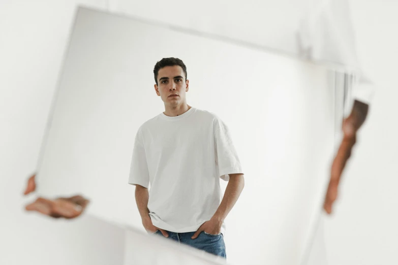 man stands in front of mirrors with his hands in his pockets