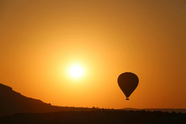 two  air balloons are flying at sunset