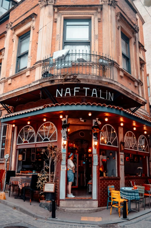 a building with an entrance is surrounded by tables and chairs