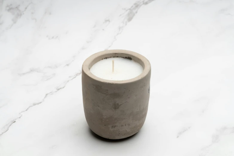 a candle sits inside of a concrete container