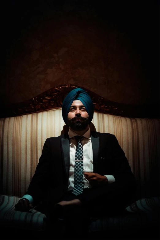 a man in a turban sits and looks forward