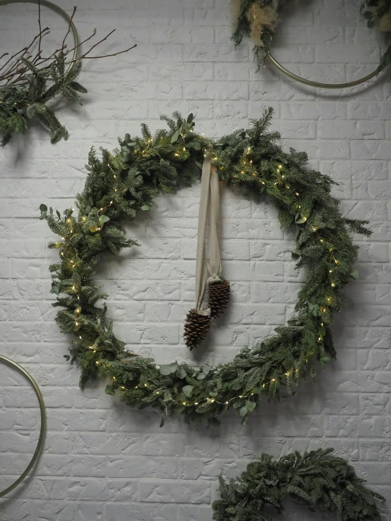 christmas wreath on a brick wall with an umbrella and cones