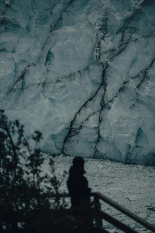 a person standing on a steps in front of a large ice cave