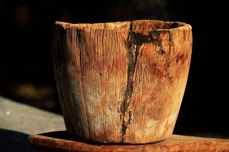 a wooden cup that is standing on top of a plate