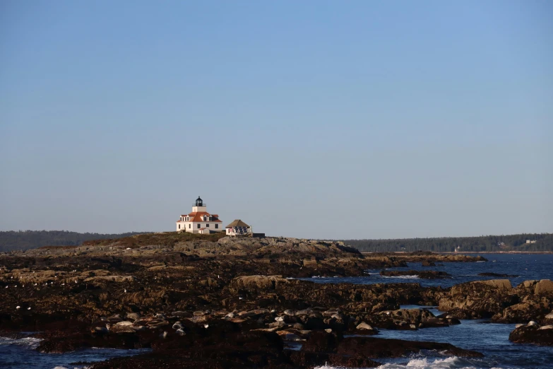 a lighthouse sitting on top of an island in the ocean