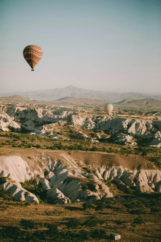 a balloon flies low over the mountains