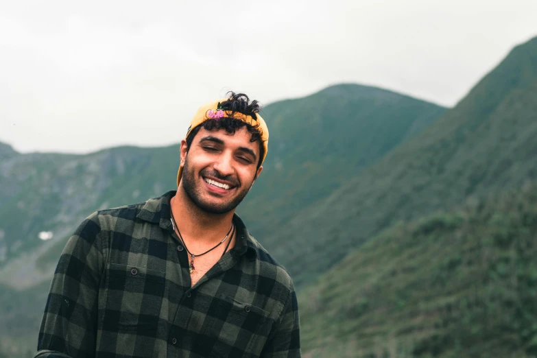 a man smiles with a beard and hat on his head