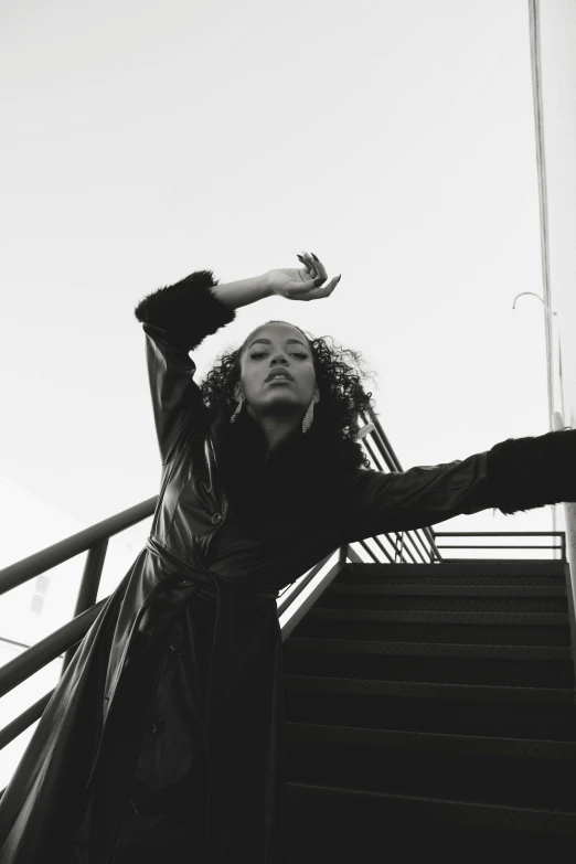 woman leaning on a staircase looking up