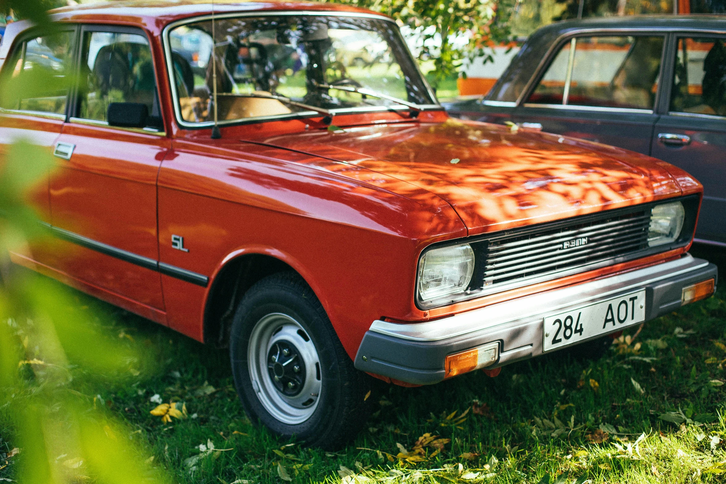 the old car is parked on the grass