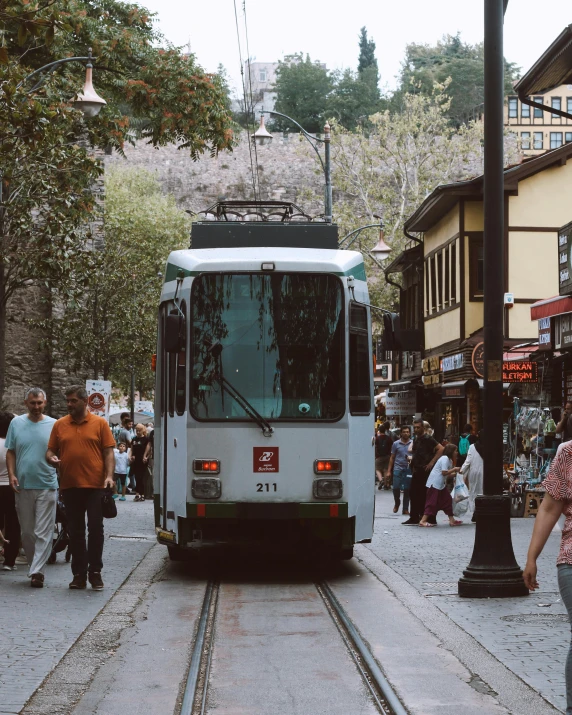 a bus driving down a street next to a clock tower