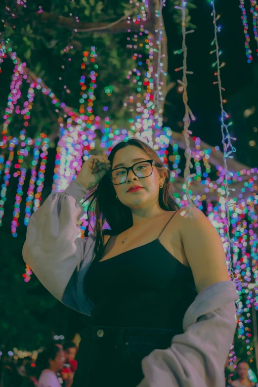 a woman wearing glasses is posing for the camera