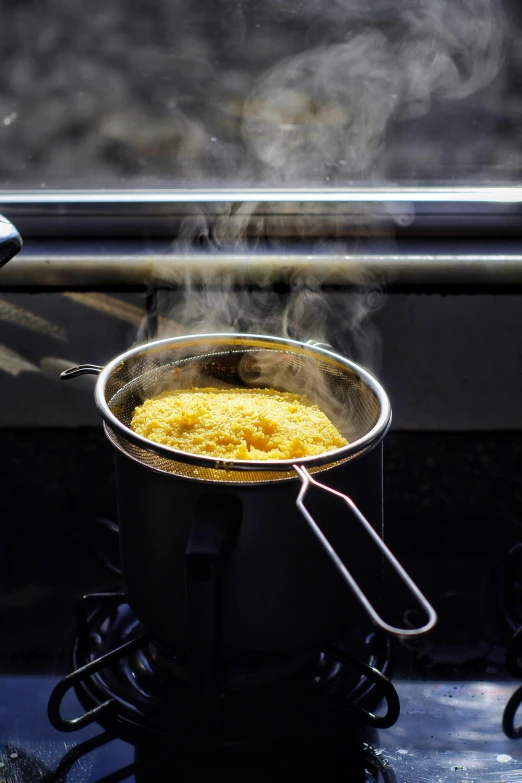 some food in the pot being cooked and steam rising