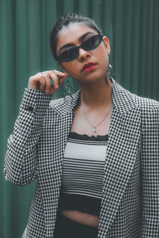 a woman is wearing sunglasses while posing for the camera