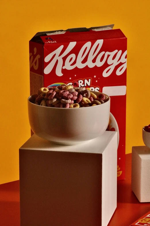 the cereals have a box on top and a cup in front