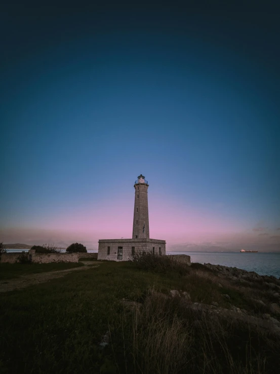 a tall lighthouse standing in front of a body of water