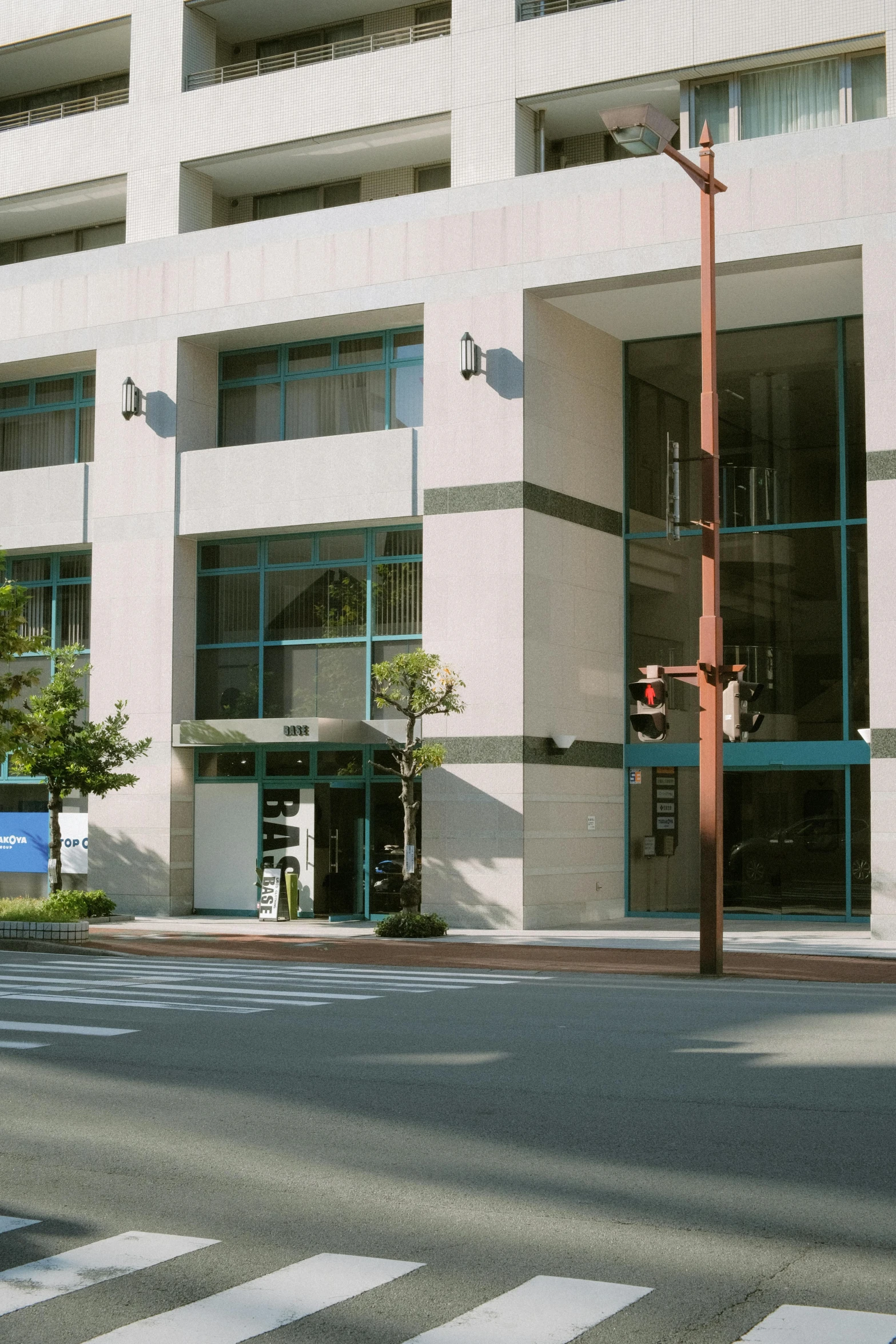 an office building with a large door and street signs in front