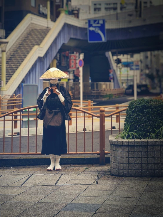 a lady standing on the sidewalk with an umbrella