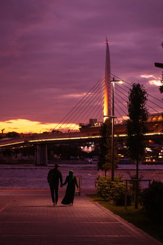 two people walking down the street, as a purple sky comes down behind them