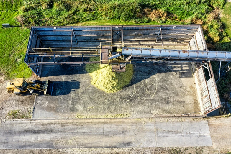 an aerial view of a tractor trailer on the ground near a small building