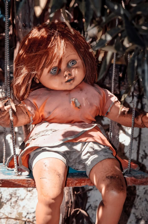 a doll sitting on top of a swing