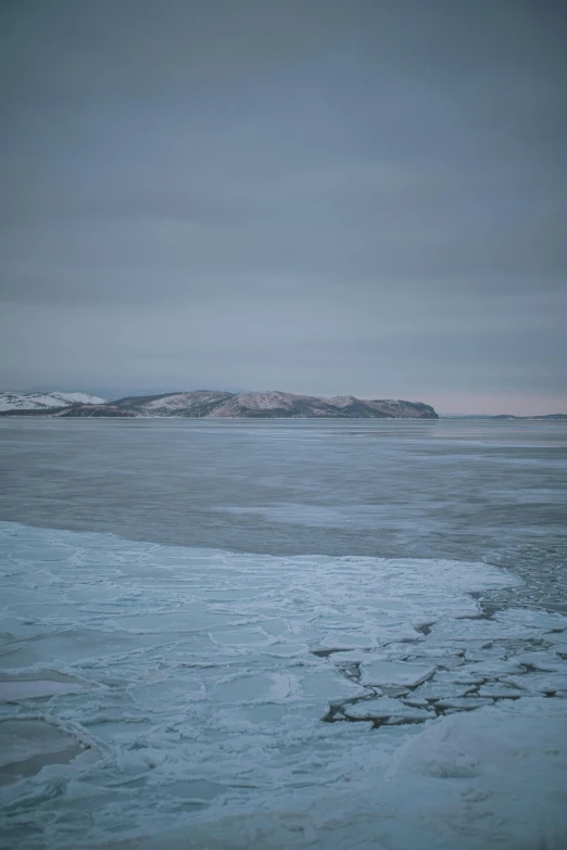 a lone person walking on an ice covered lake