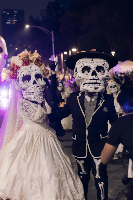 a wedding couple in skeleton makeup and a bride with flowers