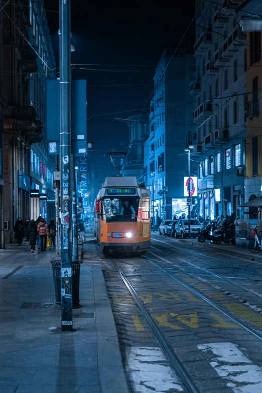 a train moving down a city street at night