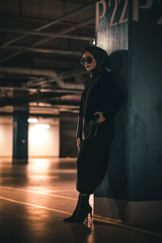 woman in black standing by large parking garage sign