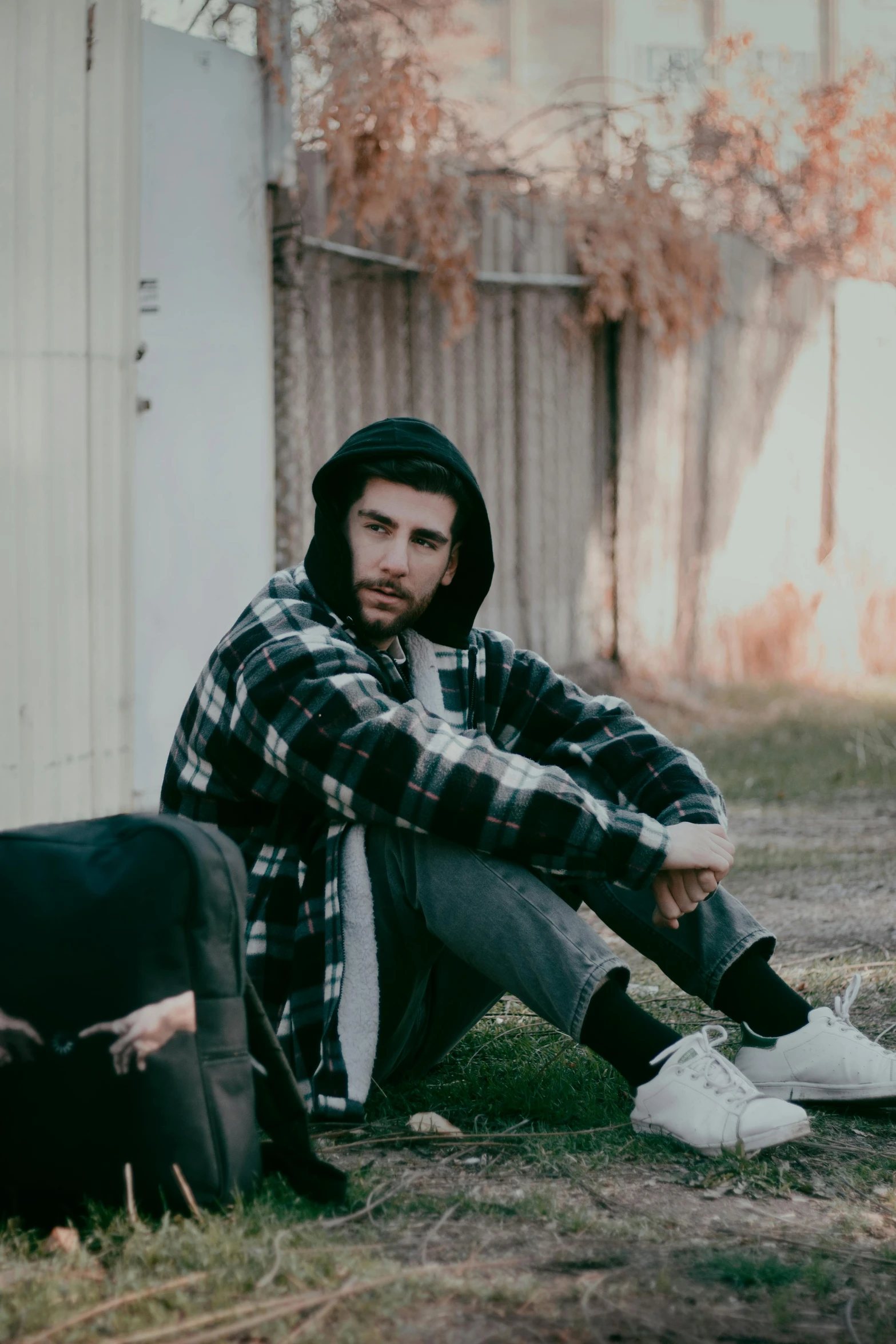 a man sitting on the grass and staring into the distance