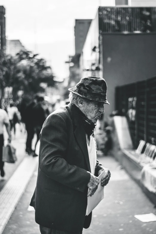 a man with a hat eating and walking on the street