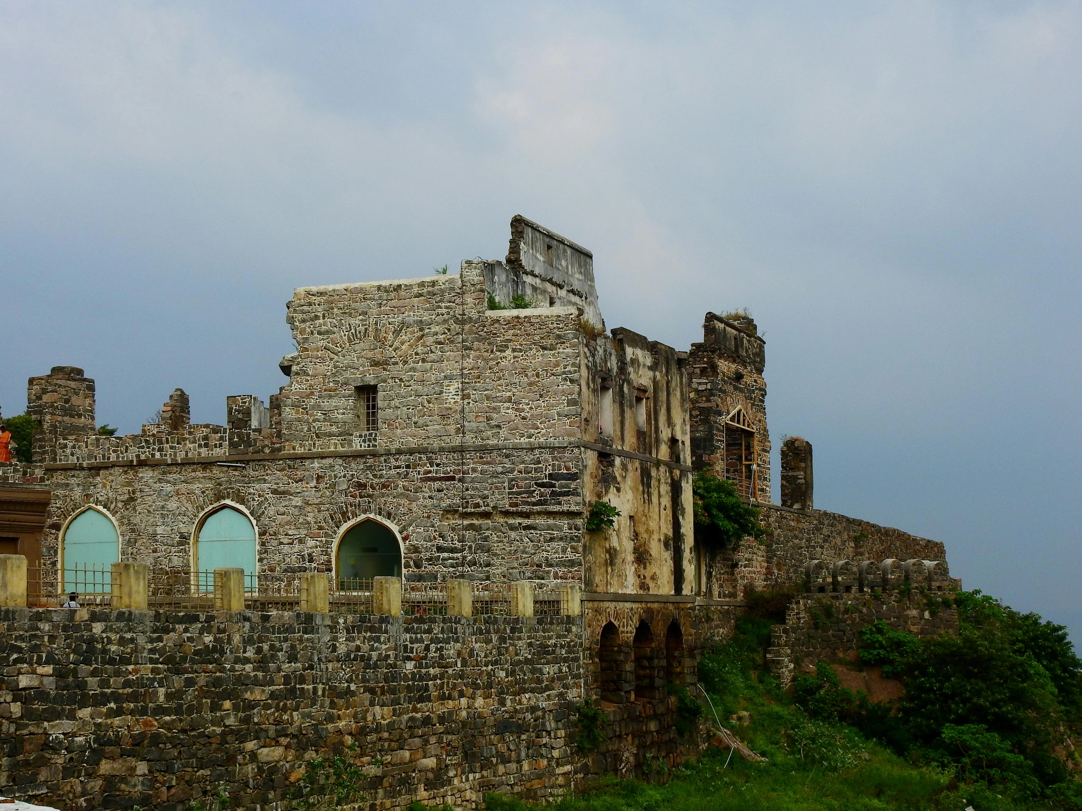 an old castle stands atop a hill with trees on top