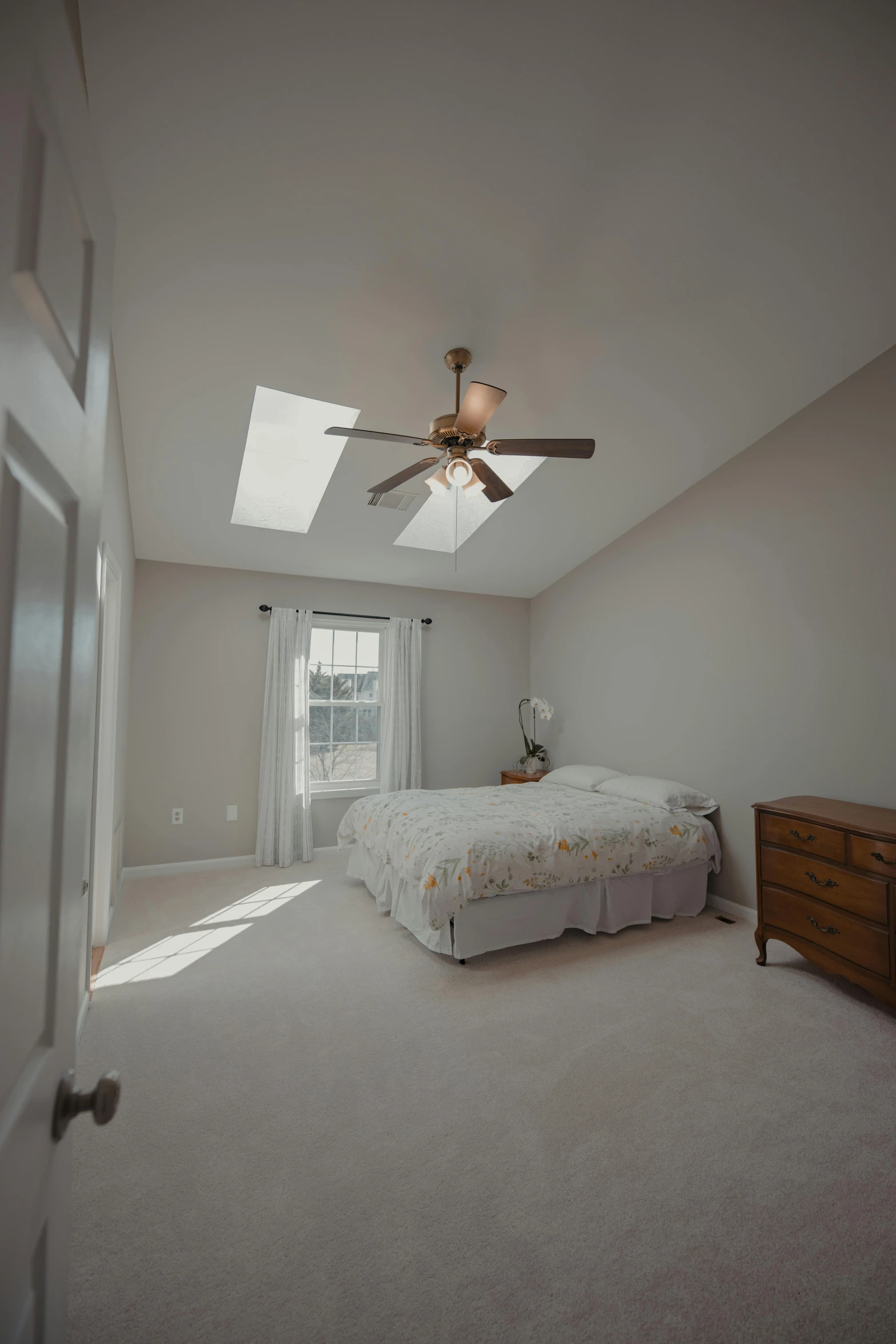 a very clean bedroom with a large bed and ceiling fan