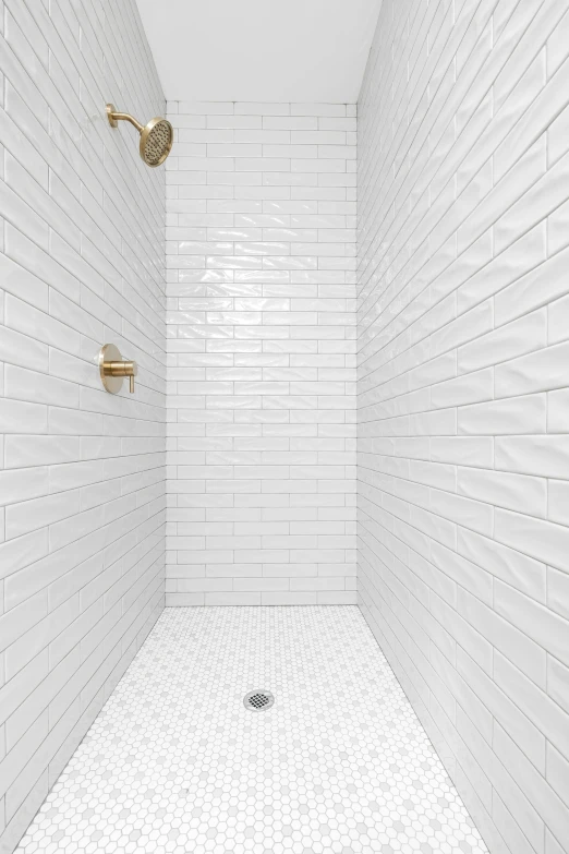 a bathroom shower with white brick walls and floor tiles