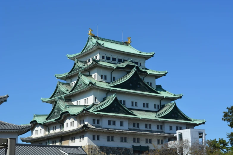 a building with many windows and green roof tiles