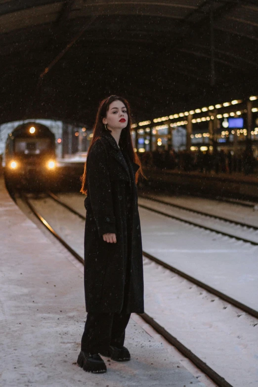 the woman is waiting for the train to arrive