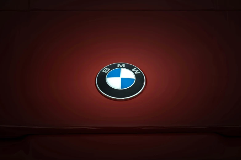 the bmw emblem is seen on a red and black background