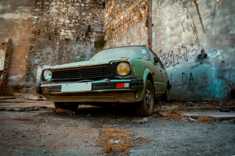 old abandoned and rusted vehicle with graffiti on a wall