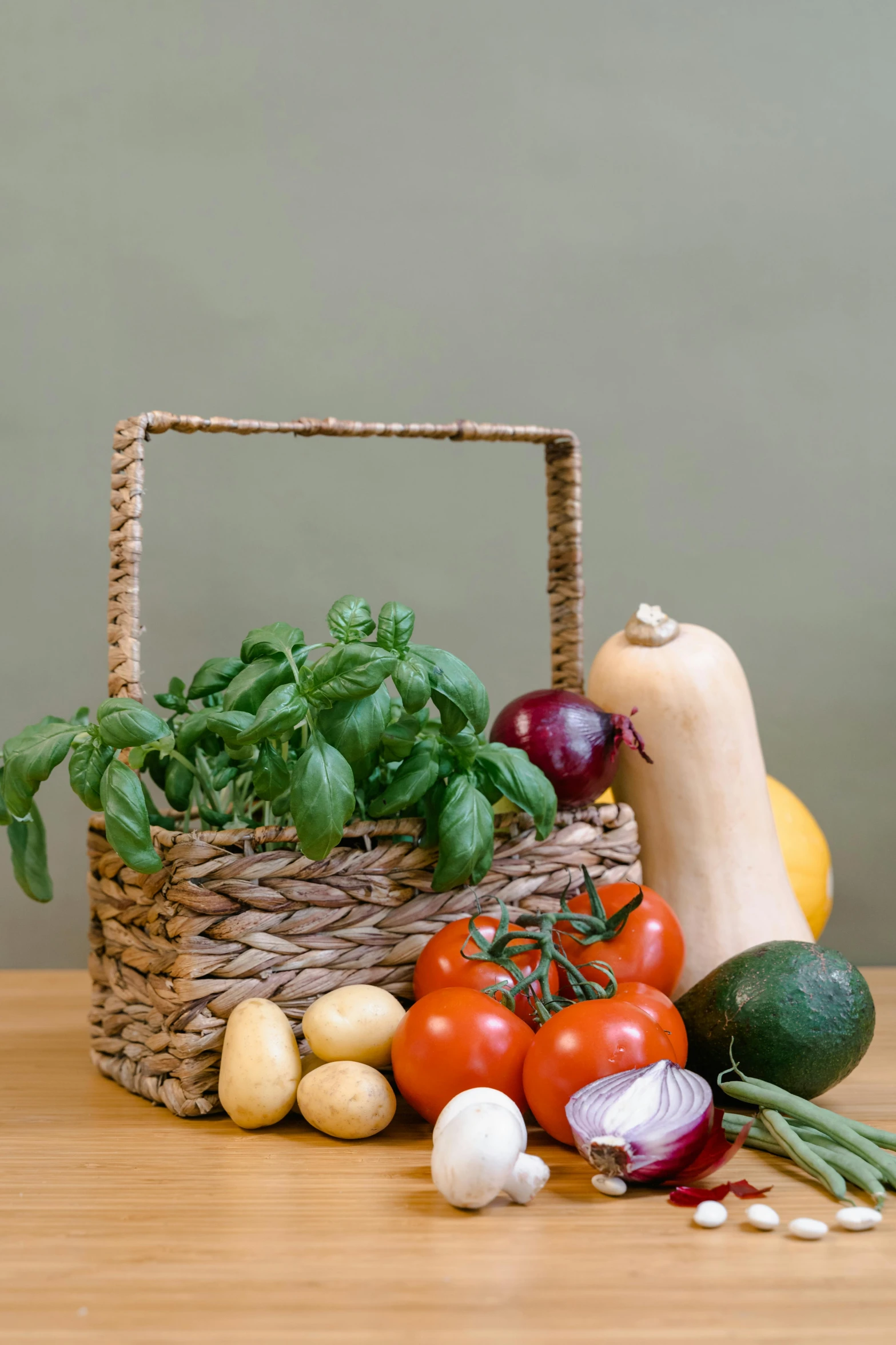 vegetables are gathered in a basket on a table