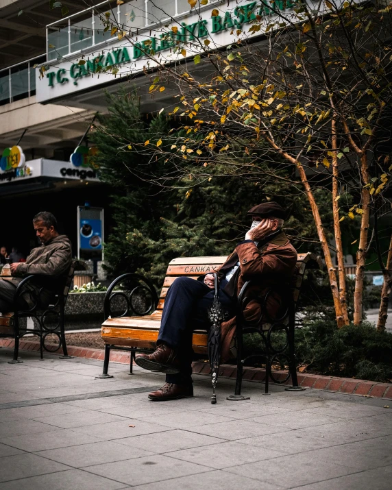 a man on a bench with a sign behind him