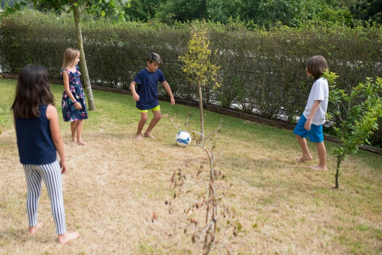 three s are playing soccer outside in the grass