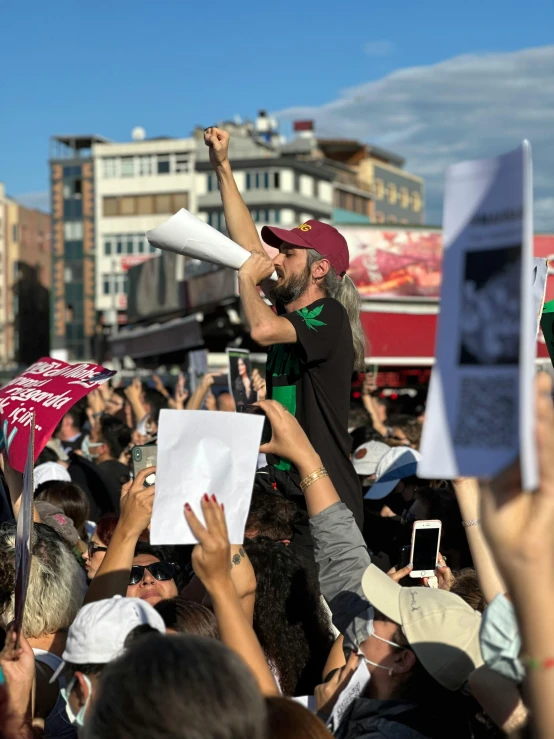 a man on a stage surrounded by people holding up their cell phones