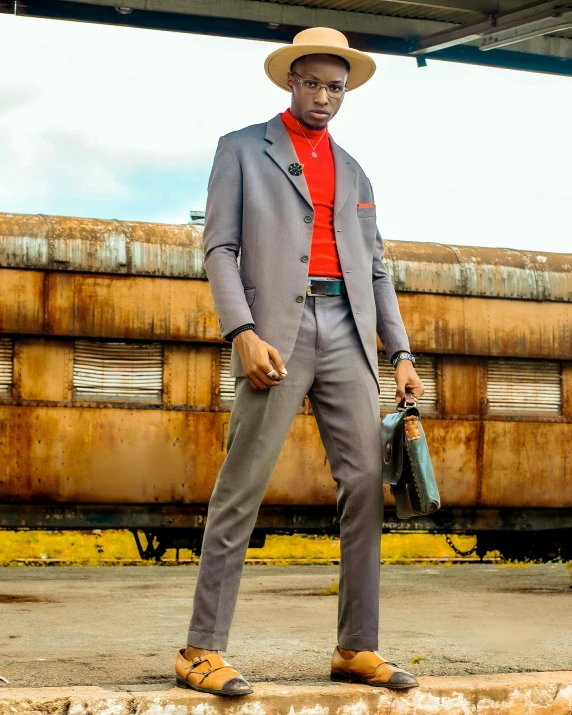 a man in a suit standing in front of train cars