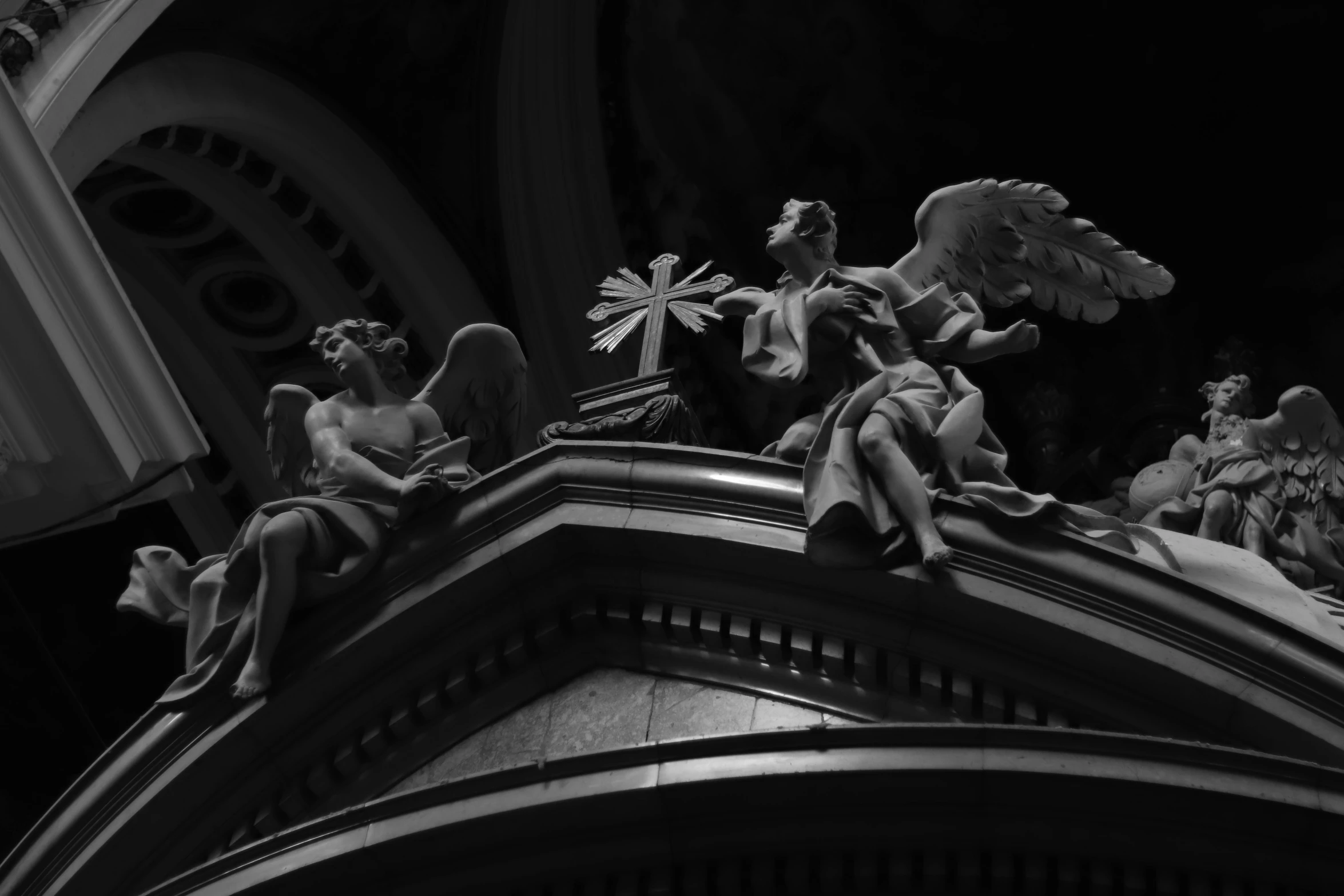 three angel statues on top of an architectural building