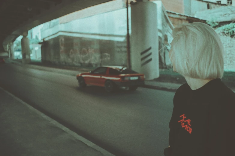 a woman in a black shirt looks at a car